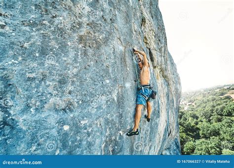Strong Muscular Man Rock Climber With Naked Torso Dynamically Climbing
