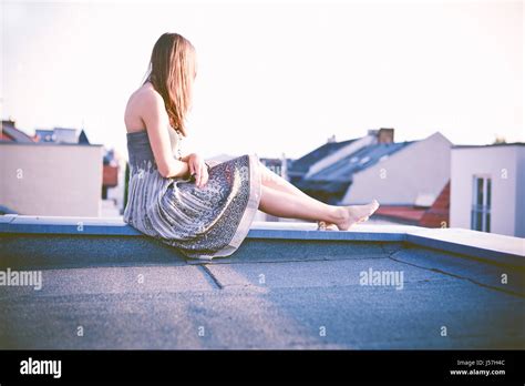 Young Woman Sitting On Rooftop Stock Photo Alamy