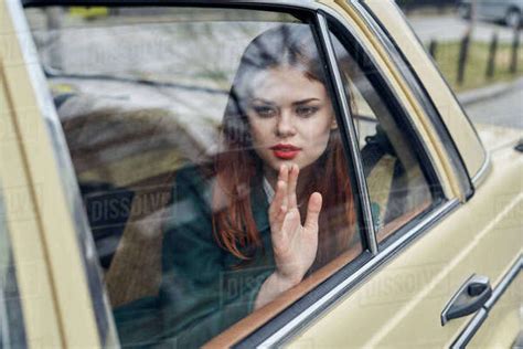 Pensive Caucasian Woman In Back Seat Of Car Leaning On Window Stock