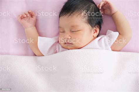 Cute Asian Newborn Baby Girl Sleeping In Bed With Pink Blanket Stock