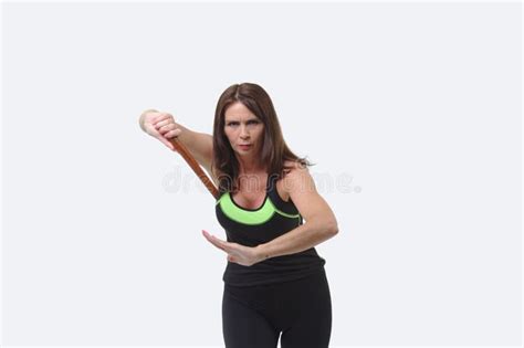 Attractive Middle Aged Woman In Sports Gear Holding A Tanto Or Wooden
