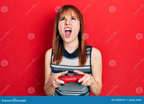 Redhead Young Woman Playing Video Game Holding Controller Angry And Mad