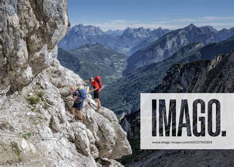 Couple Rock Climbing On Sunny Day At Dolomiti Bellunesi National Park