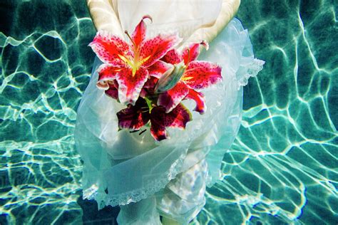 Caucasian Woman Wearing Dress Holding Bouquet Of Flowers Underwater