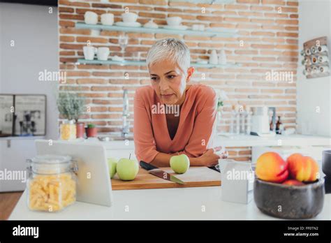 Older Caucasian Woman Cooking In Kitchen Stock Photo Alamy
