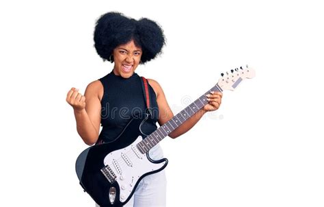 Young African American Girl Playing Electric Guitar Screaming Proud