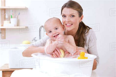 Mother Giving Baby Babe A Bath In Basin Stock Photo Dissolve