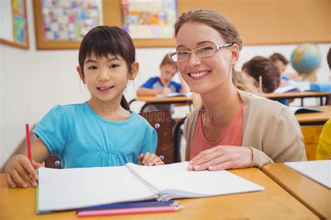 Pretty Teacher Helping Pupil In Classroom Stock Image Image Of