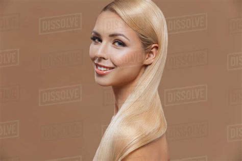 Beautiful Smiling Blonde Woman With Perfect Long Hair Isolated On Brown Stock Photo Dissolve