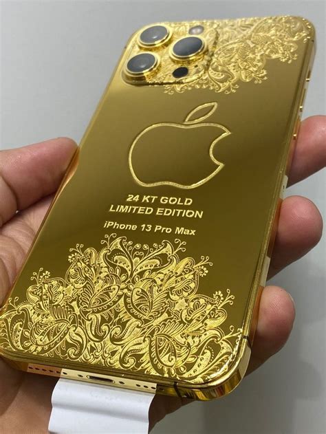 A Person Holding An Iphone In Their Hand With The Gold Case On Its Side