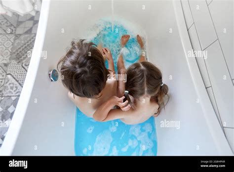 nahaufnahme von kinderbeinen in der badewanne mit klarem blauem wasser