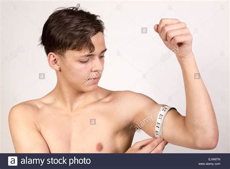 White Teenage Boy Measuring His Bicep Muscle Studio Shot