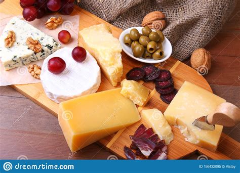 Assortment Of Cheese With Fruits Grapes Nuts And Cheese Knife On A