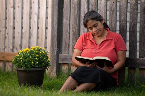 hispanic woman reading her bible by flower pot stock image image of green back 124649155