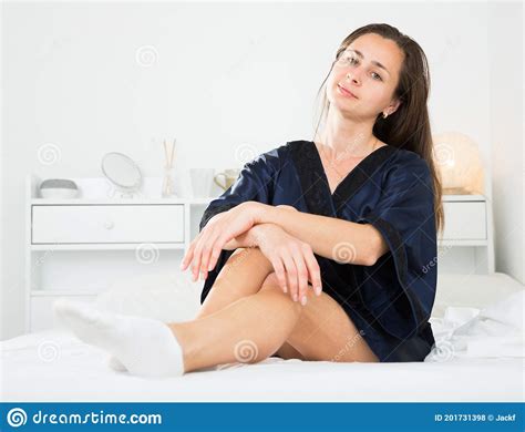 Cute Lady In Black Silk Robe Posing In Bed In Bedroom Stock Photo
