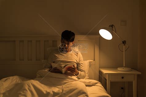 晚上坐在床头看书的年轻男性高清图片下载 正版图片500701276 摄图网