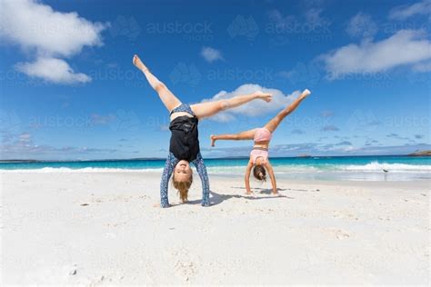 Image Of Two Children Doing Cartwheels On White Beach Sand Austockphoto