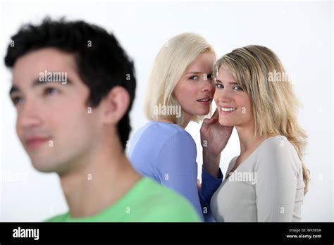 Two Girls Gossiping About Man Stock Photo Alamy