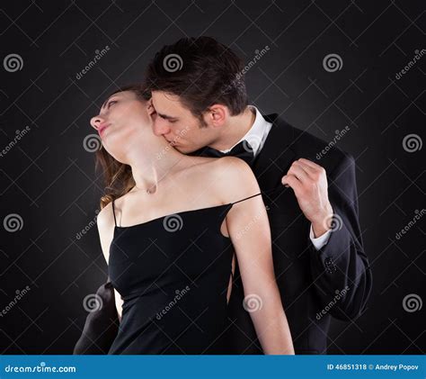Man Kissing Woman On Neck While Removing Dress Strap Stock Photo