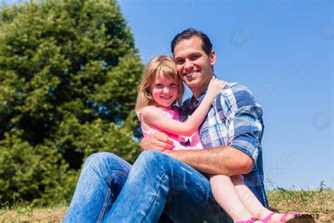 Girl On Dads Lap Sitting On Meadow Or In Field Stock Photo 550412