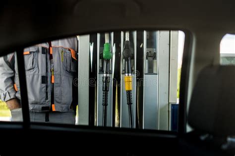 Gas Station Worker Standing Near Fuel Station Pumps View Through Car