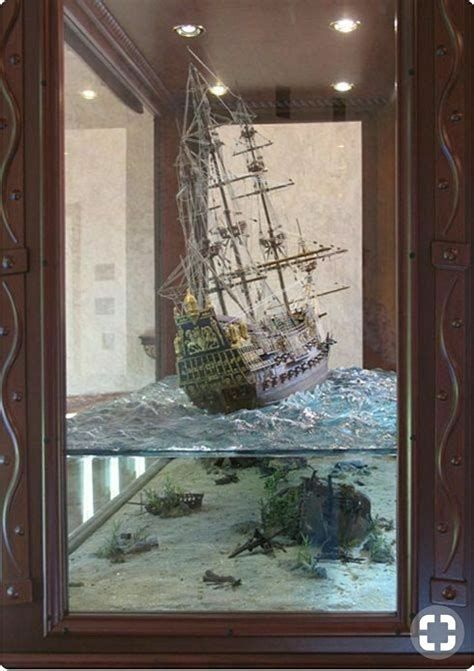 A Model Ship In A Glass Case With Other Items On The Bottom And Below It
