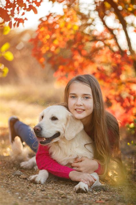 Portrait of Young Girl Sitting on the Ground with Her Dog Retriever in