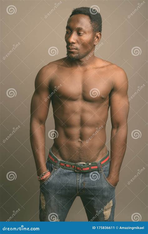 Young Handsome African Man Shirtless Against Gray Background Stock