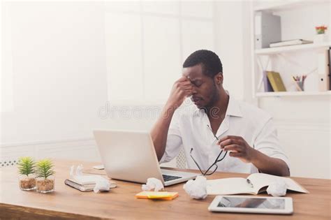 Tired African American Employee In Office Work With Laptop Stock Photo