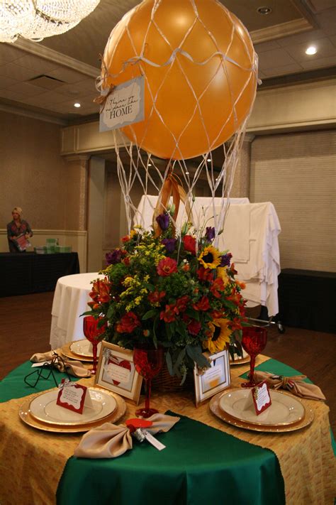 A Table Topped With Plates Covered In Flowers Next To An Air Balloon