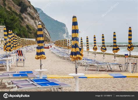 Het strand bestaat uit fijn zand en grind en de bodem van de azuurblauwe zee is kleiachtig en zacht. Strand i Numana i Conero riviera, Marche, Italien ...