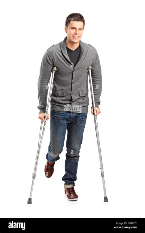 Full Length Portrait Of An Injured Young Man On Crutches Stock Photo