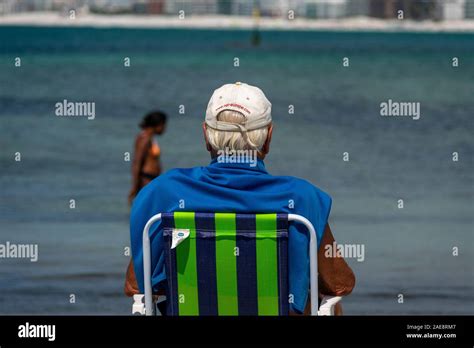 Old Man Staring At The Sea At A Tropical Beach On A Sunny Day Stock