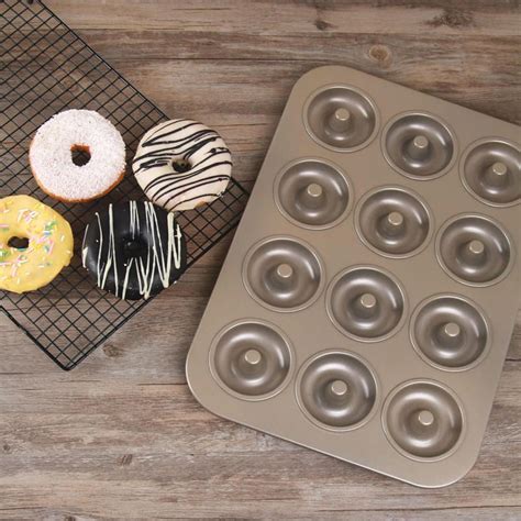 A Muffin Pan With Several Donuts In It Next To A Cooling Rack On A