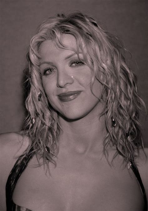 a black and white photo of a woman with blonde hair wearing a strapless dress