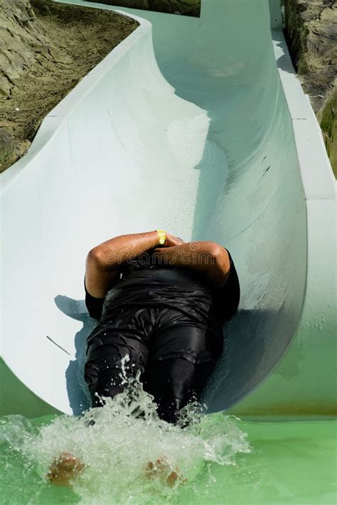A Man Is Sliding Down Water Slide At The Theme Park Stock Photo Image