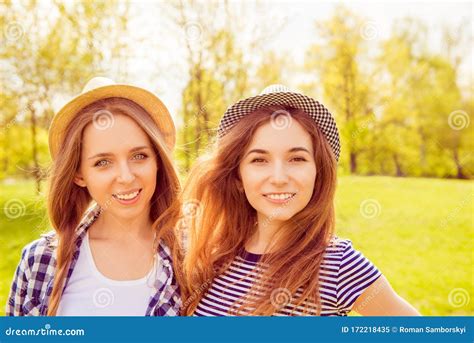 Portrait Of Young Girls In Hats With Beamings Smiles In The Park Stock