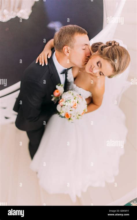 Handsome Groom Kisses His Beautiful Bride Close Up Top View Stock