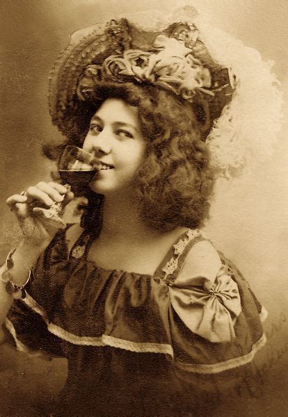 an old photo of a woman wearing a hat and holding a wine glass in her hand