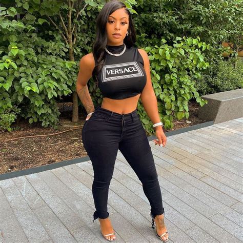A Woman In Black Pants And Crop Top Posing For The Camera