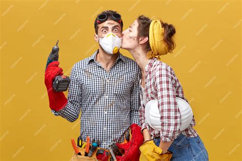 Free Photo Pretty Female Kissing Her Husband In Cheek Being Thankful To Him For Repairing Her