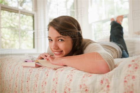 Mixed Race Girl Laying In Bed Writing In Journal Stock Photo Dissolve