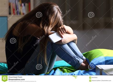 Droevige Tiener Met Een Telefoon In Haar Slaapkamer Stock Afbeelding Image Of Intimideer
