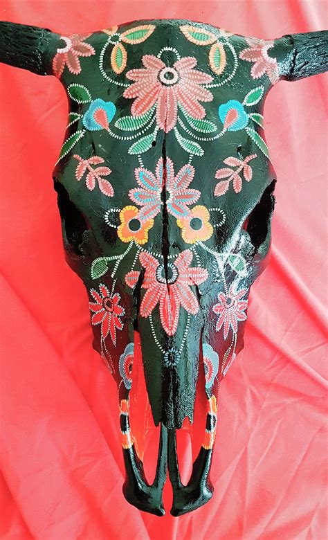 An Animal Skull With Flowers Painted On Its Face And Horns Are Shown
