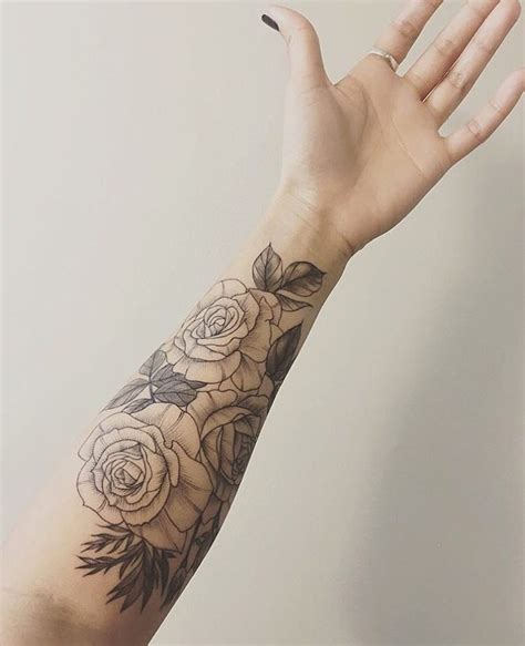 This rose design is the perfect size for this part of the woman's arm. Another set of classic roses, wraps around the forearm ty ...