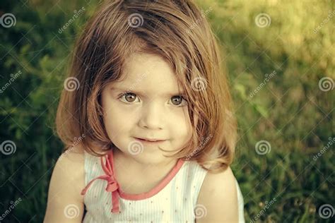Charming Little Girl Girl With Brown Eyes On Cute Face Sitting On