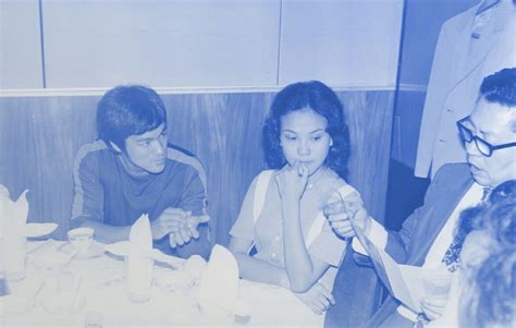 An Old Black And White Photo Of Three People Sitting At A Table With