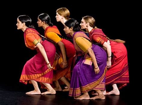 A Group Of Women Standing Next To Each Other In Front Of A Black