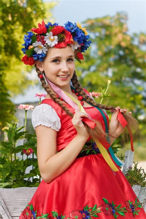 Girl With Two Braids In Ukrainian Traditional Dress Flowers Wreath With Ribbons Red Earrings