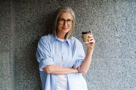Charming Mature Grey Hair Woman At Retirement Time Drink Coffee Using Paper Cup Standing